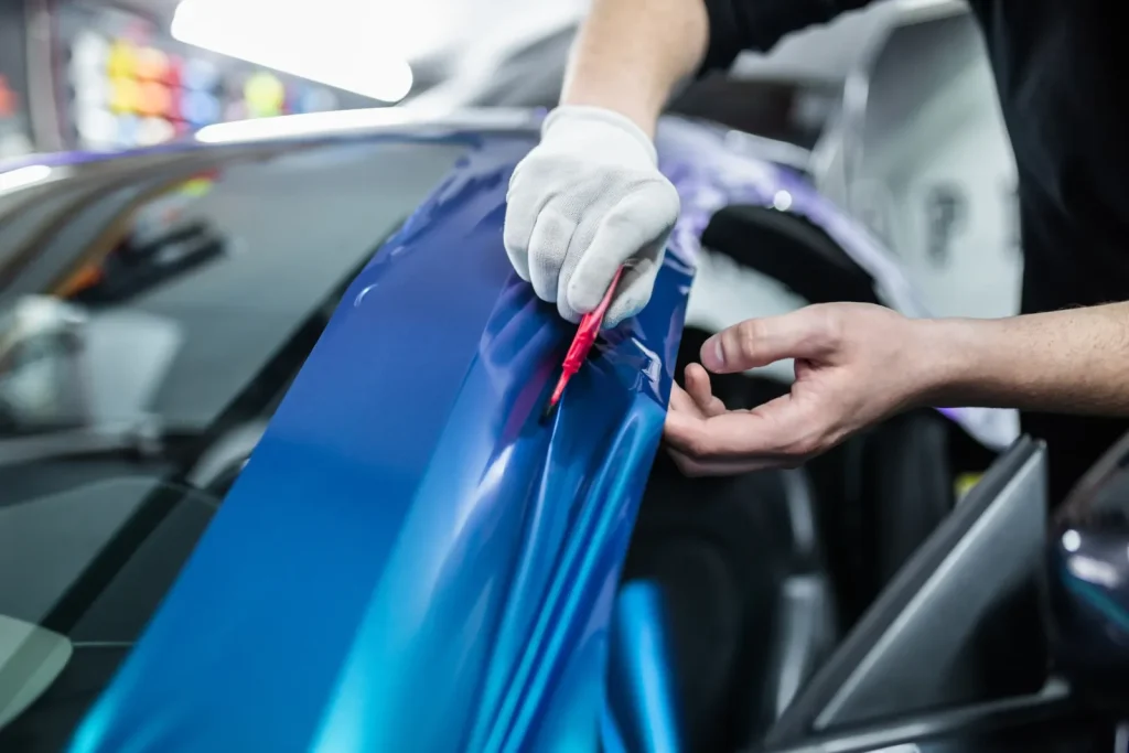 Blauwe folie wordt op een auto aangebracht